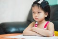 Asian student girl upset with homework. Kindergarten child unhappy learning. Sad face children. Kid aged 4-5 years old Royalty Free Stock Photo