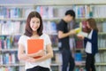 Asian student lady smile and read a book in library Royalty Free Stock Photo