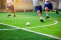 Asian student play plastic soccer ball on green artificial turf