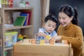 Asian student in preschool use a letter box make a study word in class room with his teacher Royalty Free Stock Photo