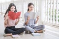 Asian student sitting outside school building reading book Royalty Free Stock Photo