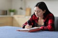Asian student taking notes studying in the kitchen Royalty Free Stock Photo