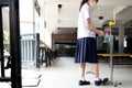 Asian student wearing face mask,child girl using their foot to press the alcohol antiseptic gel,pedal on alcohol gel equipment