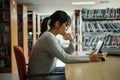 Asian student woman read books in library at university. Young girl stress tired have problem while study hard. Sadness concept Royalty Free Stock Photo