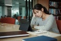 Asian student woman read books in library at university. Young girl stress tired have problem while study hard. Sadness concept Royalty Free Stock Photo