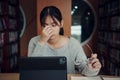 Asian student woman read books in library at university. Young girl stress tired have problem while study hard. Sadness concept Royalty Free Stock Photo