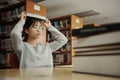Asian student woman read books in library at university. Young girl stress tired have problem while study hard. Sadness concept Royalty Free Stock Photo