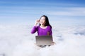 Asian student working with computer laptop on top of clouds Royalty Free Stock Photo