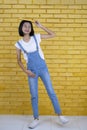 Asian student young girl hold book on her head  with yellow blocks wall in happy emotion Royalty Free Stock Photo