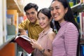 Asian students group reading book in library, learning and education concept.