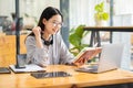 Asian students hang wireless headphones around their necks and write laptops to learn languages online. Watch and listen to laptop