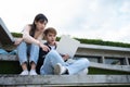 Asian students sitting on steps and use computer laptops to discuss before exams, Student lifestyle at university. Group of Royalty Free Stock Photo
