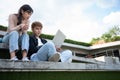 Asian students sitting on steps and use computer laptops to discuss before exams, Student lifestyle at university. Group of Royalty Free Stock Photo