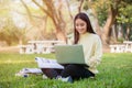 Asian students use notebook computers and tablet to work and study online in garden at home during the coronavirus epidemic and Royalty Free Stock Photo