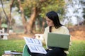 Asian students use notebook computers and tablet to work and study online in garden at home during the coronavirus epidemic and Royalty Free Stock Photo