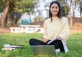 Asian students use notebook computers and tablet to work and study online in garden at home during the coronavirus epidemic and Royalty Free Stock Photo