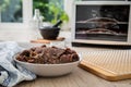 Asian style marinated raw beef strips for homemade jerky dried meat with sesame and chili on dehydrator drying tray, wooden board Royalty Free Stock Photo