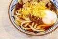 Asian style soup with japanese udon noodles, pork, boiled eggs, Udon noodle hot pot, close-up in a bowl on the table. Royalty Free Stock Photo