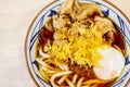 Asian style soup with japanese udon noodles, pork, boiled eggs, Udon noodle hot pot, close-up in a bowl on the table. Royalty Free Stock Photo
