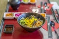 Asian style soup with udon noodles, slices of beef, vegetables close-up in a bowl on the table, top view Royalty Free Stock Photo