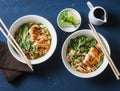 Asian style spicy udon noodle soup with fried chicken on a blue background Royalty Free Stock Photo