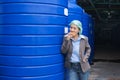 Asian supervisor woman standing eating bread with haste during lunch break in water tank warehouse in processing factory