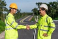 Asian survey engineers handshake on road construction site, after use theodolite mark a expressway at highway success, Civil