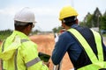 Asian surveyor engineer two people checking level of soil with Surveyor\'s Telescope equipment to measure leveling