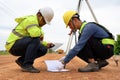 Asian surveyor engineer two people checking level of soil with Surveyor's Telescope equipment to measure leveling