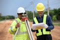 Asian surveyor engineer two people checking level of soil with Surveyor\'s Telescope equipment to measure leveling