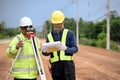 Asian surveyor engineer two people checking level of soil with Surveyor\'s Telescope equipment to measure leveling