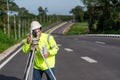 Asian surveyor engineer worker making measuring with theodolite on road works. survey engineer at road construction site, Surveyor