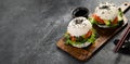 Asian sushi burger, soy sauce, chopstick on dark background. Trendy hybrid food