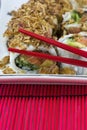 Asian sushi with red chopsticks on the white plate