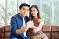 Asian sweet adorable couple sitting on sofa in living room at home, showing model of house, smiling with happiness. House, Loan, Royalty Free Stock Photo