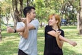 Asian sweet couple warm up their bodies by stretching arms before morning jogging exercise in the park. Royalty Free Stock Photo