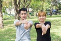 Asian sweet couple warm up their bodies by stretching arms before morning jogging exercise in the park. Royalty Free Stock Photo