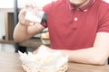 Asian syoung man with casual red t-shirt enjoy having breakfast, eating french fries with salt, Young man cooking food in the