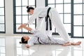 Asian Taekwondo teacher and student are action to get muscle relaxation by different posture before and after training