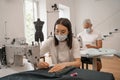 Asian tailor in medical mask working