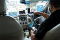 Asian taxi driver in a medical mask. The interior of an Asian taxi. View from the rear seat