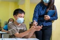 Asian teacher and children with face mask at school after covid-19 quarantine and lockdown and using antiseptic for coronavirus Royalty Free Stock Photo