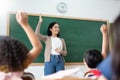 Asian teacher and Diverse Multi ethnic Little Student raising their hands in classroom Royalty Free Stock Photo