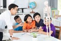 Asian teacher explains a human body structure to little pupil Royalty Free Stock Photo