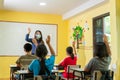 Asian teacher with face mask welcoming children back at school after lockdown