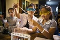 Asian teacher and student in school science laboratory room