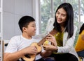 Asian teacher teach ukulele to disabled boy.