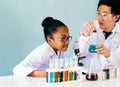 Asian teacher teaching science class to African American student