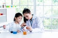 Asian teacher is teaching a 6 year old girl, about scientific experiments Royalty Free Stock Photo