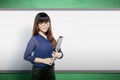 Asian teacher woman with files standing in the classroom with a whiteboard background Royalty Free Stock Photo